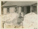 Image of Front path cut through snow bank at camp- Miriam Flowers sitting on steps